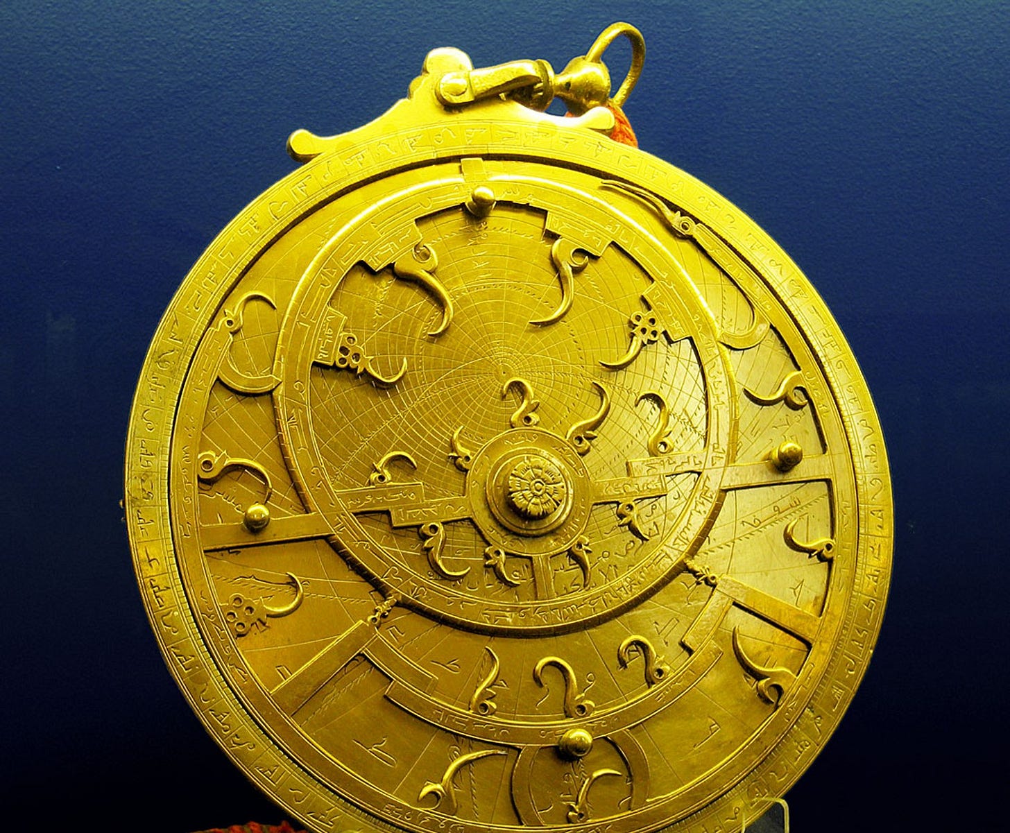 A Persian astrolabe, a single brass disc instrument engraved with star positions and measurement scales