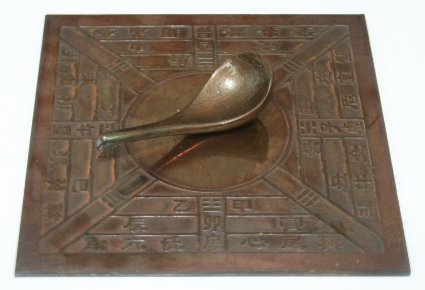 A si nan, a reconstructed lodestone spoon resting on a bronze diviner's plate
