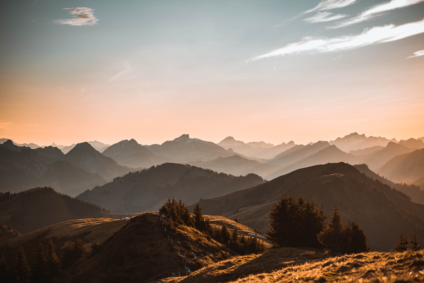 Golden sunrise light over layered mountain ridges